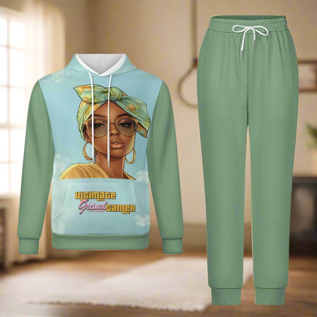 Stylish two-piece hoodie and jogger set in sage green featuring an illustration of a fashionable woman with glasses and a headwrap on the hoodie. The text 'Ultimate Grand Gamer' is printed on the hoodie