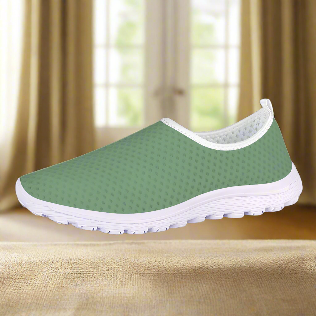 The Sunny Sophistication Cushion Kicks are green slip-on sneakers with a white sole and mesh fabric design, ideal walking shoes due to their slip-resistant features.