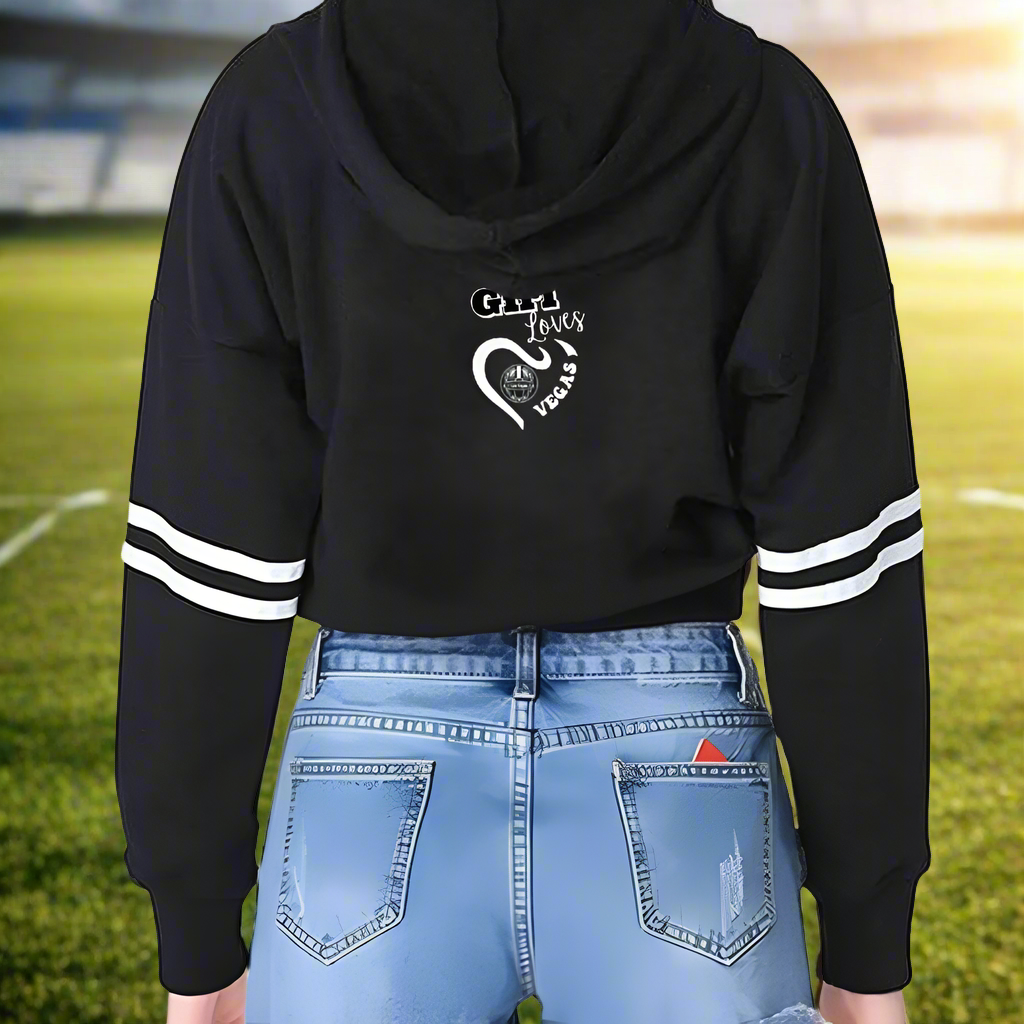 This Girl Loves Vegas Women's Long Sleeve Crop Hoodie is crafted in a casual style featuring white striped sleeves and a heart graphic on the back with the text 'City of Love.' The black cropped hoodie boasts high-quality printing for both durability and a stylish look.